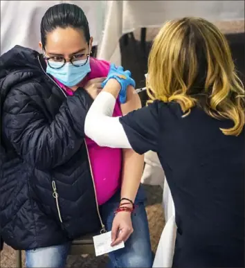  ?? Alexandra Wimley/Post-Gazette ?? Valerie Lopez, of Pine, receives a COVID-19 vaccine Wednesday during a vaccinatio­n clinic for pregnant women at UPMC Magee-Womens Hospital in Oakland.