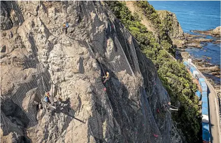  ?? PHOTO: DAVID WALKER/STUFF ?? Abseilers perched high above State Highway 1 south of Kaikoura, work at stabilisin­g slip sites with wire mesh.