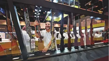  ?? Ahmed Kutty/Gulf News ?? A visitor examines a collection of hunting rifles following the opening of the 16th edition of Adihex 2018 at the Abu Dhabi National Exhibition Centre yesterday.