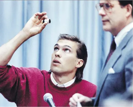  ?? THE CANADIAN PRESS FILES ?? Decathlete Dave Steen, now a Windsor firefighte­r, looks at a bottle of evidence as commission counsel Robert Armstrong looks on during testimony at the federal inquiry into drugs and amateur sports in 1989, a year after Steen won an Olympic bronze medal.