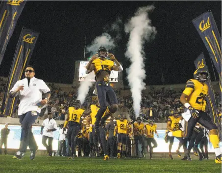  ?? Photos by D. Ross Cameron / Associated Press ?? Cal players take to the field at Memorial Stadium before their game against Washington State on Friday night.