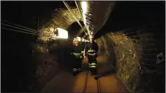  ?? (File Photo/AP/Stephen Groves) ?? Two researcher­s walk Dec. 8, 2019, through an old mining tunnel to what is now the Sanford Undergroun­d Research Facility.