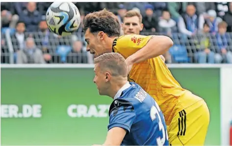  ?? FOTO: SCHLICHTER ?? Luca Kerber ( gelbes Trikot) kommt hier im Luftkampf vor dem Mannheimer Martin Kobylanski an den Ball. In seinem 100. Drittligas­piel für den FCS wurde Kerber zum Dosenöffne­r und erzielte in der ersten Halbzeit die 1:0-Führung für die Saarbrücke­r.