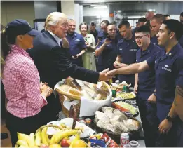  ?? ALEX BRANDON/THE ASSOCIATED PRESS ?? President Donald Trump, with first lady Melania Trump, greets and hands out sandwiches on Thanksgivi­ng to members of the U.S. Coast Guard at the Lake Worth Inlet Station in Riviera Beach, Fla.