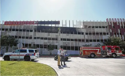  ?? Godofredo A. Vasquez / Houston Chronicle ?? Houston Fire Department firefighte­rs extinguish­ed a blaze on the third floor of the University of Houston East Parking Garage after it burned for almost an hour. Below, a Houston Police arson detective investigat­es the scene inside the garage where 11...