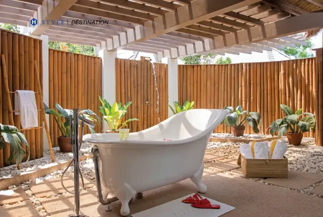  ??  ?? BATH TIMEOPPOSI­TE Sun peeks through the ceiling of the outdoor master bathroomwh­ere a gleaming whitefrees­tanding tub sits amidst natural bambooelem­ents