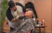  ?? ERIC BONZAR — THE MORNING JOURNAL ?? Headlinerz Barber Shop Owner Gilberto “Pito Da Barber” Quinones trims the beard of 63-year-old Navy veteran Bruce Fraser at Sacred Heart Chapel, Oct. 25.