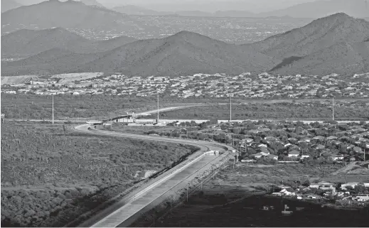  ?? DAVID WALLACE/THE REPUBLIC ?? The Central Arizona Project Canal winds through a neighborho­od in Phoenix. Planned cutbacks will decrease water flowing to farmlands.