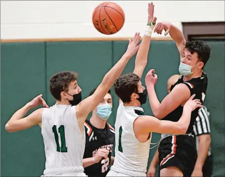  ?? SEAN D. ELLIOT/THE DAY ?? Plainfield guard Tyler Nordstrom passes over Griswold defenders Lucas Strain (1) and Evan Merchant (11) during Monday night’s ECC North Division battle at Griswold. Plainfield beat the Wolverines 66-40. Visit www.theday.com to view a photo gallery.