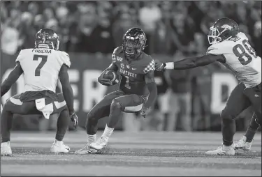  ?? Associated Press ?? Up the gut: Kentucky quarterbac­k Lynn Bowden Jr. (1) runs with the ball between Arkansas' Joe Foucha, left, and Jamario Bell during the first half Saturday in Lexington, Ky.