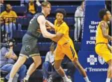  ?? STAFF PHOTO BY OLIVIA ROSS ?? Mercer’s David Craig, a McCallie graduate, and UTC’s Sam Alexis make contact during a SoCon basketball game on Feb. 11 at McKenzie Arena.