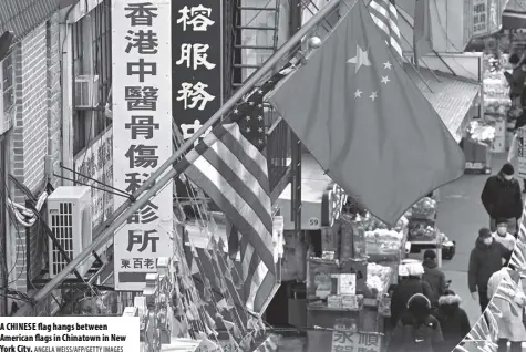  ?? ANGELA WEISS/AFP/GETTY IMAGES ?? A CHINESE flag hangs between American flags in Chinatown in New York City.