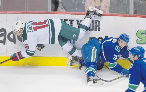  ?? ARLEN REDEKOP/PNG ?? The Minnesota Wild’s Jason Zucker falls after taking a hit from the Vancouver Canucks’ Frank Corrado during Minnesota’s win on Sunday at Rogers Arena.