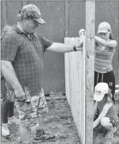  ??  ?? Volunteer Johnny Nickerson is helped by Paige Nickerson (standing) and Lucy Adams building new stalls at the Barrington Municipal Exhibition Grounds as part of a 4-H community service project. Kathy Johnson