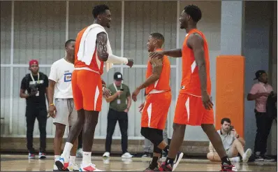  ?? Arkansas Democrat-Gazette/JEFF GAMMONS ?? Bobby Portis (left) prepares to shake hands with former University of Arkansas teammate Moses Kingsley on Sunday at Portis’ charity game at Little Rock Hall’s Cirks Arena. Portis scored a game-high 50 points, while Kingsley had 33, as their Orange team lost 161-159 in overtime when Portis’ former Chicago Bulls teammate Antonio Blakeney scored the winning basket just before the final buzzer.