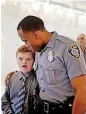  ??  ?? Reis Wathen, 8, is escorted on the red carpet by Oklahoma City police officer Trayvion Jones.