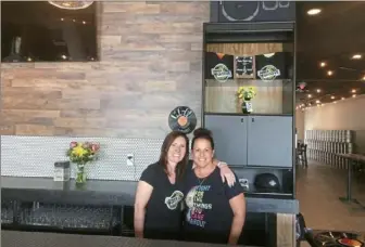  ?? Bob Batz Jr./Post-Gazette ?? Jennifer Walzer, left, and Kelly Melle behind the bar of Inner Groove Brewing, the vinyl record-themed brewery they’re opening Saturday in Verona with their brewer husbands, Kevin Walzer and Tim Melle. The L-shaped bar is in the front and the brewhouse is in the back, where kegs line one wall.