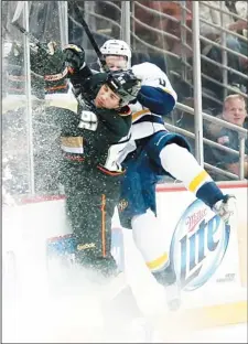  ??  ?? Patrick Maroon #62 of the Anaheim Ducks collides with the boards and Ryan Ellis #4 of the Nashville Predators at Honda Center on Feb 27, in Anaheim,
California. (AFP)