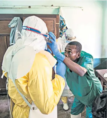  ??  ?? Health workers don protective clothing to treat patients suspected to have Ebola at Bikoro Hospital