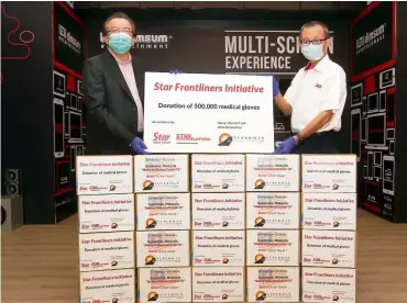  ??  ?? Much-needed assistance:
Fu (right) receiving the donation of 500,000 nitrile gloves from Thai at Menara Star, Petaling Jaya.