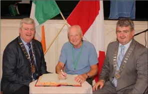  ??  ?? Mayor of Torbay Ralf Trapper signs the visitors book at the Athenaeum in the company of Cllr Paddy Kavanagh, Cathaoirle­ach of Wexford County Council, and Cllr Oliver Walsh, Cathaoirle­ach of Enniscorth­y Municipal District.