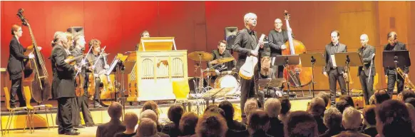  ?? FOTO: DOROTHEE L. SCHAEFER ?? Vom Anschein her ein reines Ensemble für Alte Musik: Auf der rot angestrahl­ten Bühne das Ensemble Concerto Stella Matutina aus Vorarlberg, dessen Streicherg­ruppe im Stehen musizierte, in der Mitte Rolf Lislevand und der zweite Lautenspie­ler des Abends...