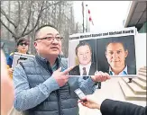  ??  ?? A file photo shows Louis Huang of Vancouver Freedom and Democracy for China holding photos of Michael Spavor and Michael Kovrig in Vancouver, Canada.