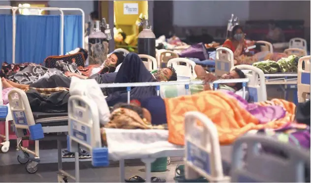  ?? Agence France-presse ?? ↑
Patients breathe with the help of oxygen masks inside a banquet hall, temporaril­y converted into a virus ward, in New Delhi on Tuesday.