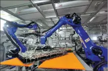  ?? WANG KAI / XINHUA ?? Robots operate the production line of Hisense Group in Qingdao, Shandong province.