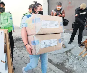  ?? AFP ?? Una funcionari­a del CNE lleva boletas a una cárcel de Quito.
