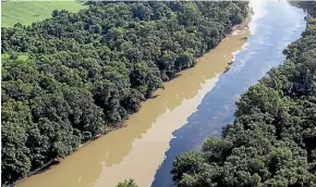  ?? AP ?? Bourbon mixes with water in the Kentucky River yesterday following a fire at a Jim Beam distillery in Woodford County, Kentucky.