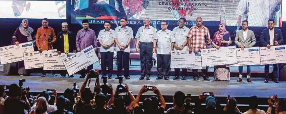  ?? [FOTO MUHD ZAABA ZAKERIA/BH] ?? Najib diiringi Ismail Sabri (enam dari kiri) bersama penerima Anugerah Usahawan SPED pada perasmian Karnival Usahawan Desa di PWTC, semalam.