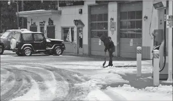  ?? Guy Mccarthy
/ Union Democrat ?? Deb “Lil Deb” Howard uses a shovel to remove slush and snow at Sierra Village Chevron on Highway 108 Monday morning.