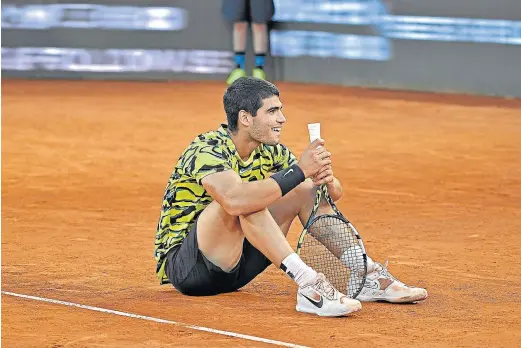  ?? FRAN GUERRA/EP ?? Carlos Alcaraz, sentado sobre la tierra batida de la Caja Mágica de Madrid, tras ganar el Masters 1.000 de la capital española.