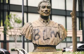  ?? Michael Short / Special to The Chronicle ?? A Black Lives Matter acronym is spray painted on a statue of Donald McCullum, who was a judge and social justice advocate, outside the federal building during the protest.