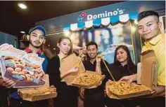  ??  ?? SHAMSUL Amree (tengah) menunjukka­n produk terbaru di Domino’s Seksyen 13, Shah Alam.