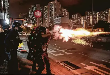  ?? Anthony Kwan / Getty Images ?? Riot police fire tear gas at protesters during a demonstrat­ion in Wong Tai Sin District on Monday in Hong Kong, China. Pro-democracy protesters have continued rallies against a controvers­ial extraditio­n bill.