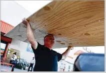  ?? JOE RAEDLE/GETTY IMAGES AL DIAZ/MIAMI HERALD ?? ABOVE: Pedro Toledo buys plywood at a Home Depot on Wednesday in Miami as he prepares for Hurricane Irma. It’s too early to know where the hurricane will hit, but the impact is already being felt as far away as Ohio.
BELOW: Traffic heads north along...