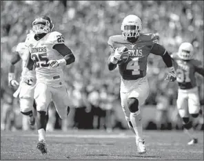  ?? AP/The Daily Texan/CHELSEA PURGAHN ?? Daje Johnson (4) of Texas returns a punt 85 yards for a touchdown as Oklahoma’s Aaron Franklin (25) tries to run him down during the Longhorns’ 36-20 victory over the No. 12 Sooners on Saturday at the Cotton Bowl in Dallas.