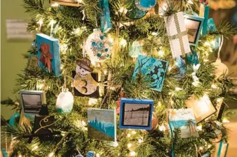  ?? ?? A tree presented by Crealdé School of Art features more than 300 small paintings, sculptures, photograph­s and drawings from 58 artists at Orlando Museum of Art’s 2021 Festival of Trees.