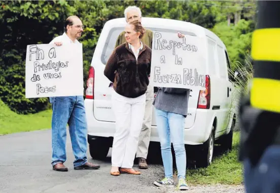  ?? JEFFREY ZAMORA ?? Vecinos de La Unión, donde se reunieron Gobierno y sindicatos, reclamaron afuera con pancartas contra líderes de la huelga.