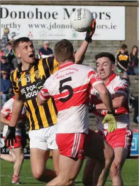  ??  ?? Conor Hearne (Shelmalier­s) pops the ball over the heads of Denis Jones and Rhys Owley.