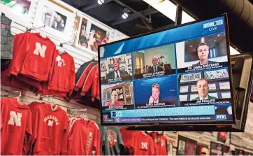  ??  ?? La tienda de artículos deportivos The Husker Hounds en Omaha, Nebraska, muestra en pantallas de televisión el 16 de septiembre del 2020 una conferenci­a de prensa para anunciar la reapertura de la temporada de fútbol