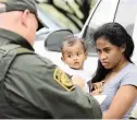  ?? PICTURE: AP ?? A migrant mother from Honduras holds her 12-month-old toddler while talking to a US Border Patrol agent after allegedly crossing the border illegally last month, near McAllen, Texas.