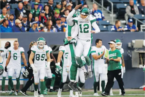  ?? JOHN WOODS/THE CANADIAN PRESS ?? Roughrider­s kicker Brett Lauther, front, and holder David Watford celebrate Saturday’s game-winning field goal against the Winnipeg Blue Bombers.