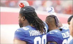  ?? Brian Blanco / Getty Images ?? Damon Harrisonof the New York Giants and Landon Collins lock arms and raise their right fists into the air during the playing of the National Anthem before the start of an NFL football game on Monday at Raymond James Stadium in Tampa.