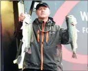  ?? NWA Democrat-Gazette/FLIP PUTTHOFF ?? Tournament leader Johnny McCombs of Morris, Ala., shows two bass from his catch Saturday that weighed 18 pounds, 15 ounces.