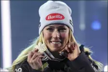  ?? ALESSANDRO TROVATI — THE ASSOCIATED PRESS ?? The United States’ Mikaela Shiffrin poses with the gold medal of the women’s World Championsh­ip giant slalom and a heart-shaped pendant containing two photos of her late father in Meribel, France, on Thursday.