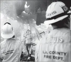  ?? Stuart W. Palley For The Times ?? CREWS BATTLE the Woolsey fire last year in Malibu. In the blaze’s crucial early hours, frontline firefighte­rs complained of a lack of communicat­ion and direction.