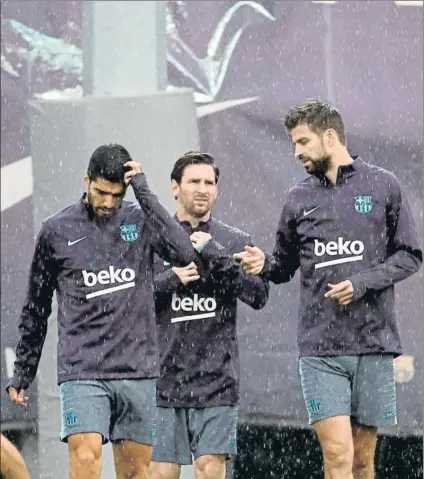  ?? FOTO: EFE ?? Luis Suárez, Leo Messi y Gerard Piqué, bajo la lluvia en la Ciutat Esportiva al inicio del entrenamie­nto de ayer por la tarde